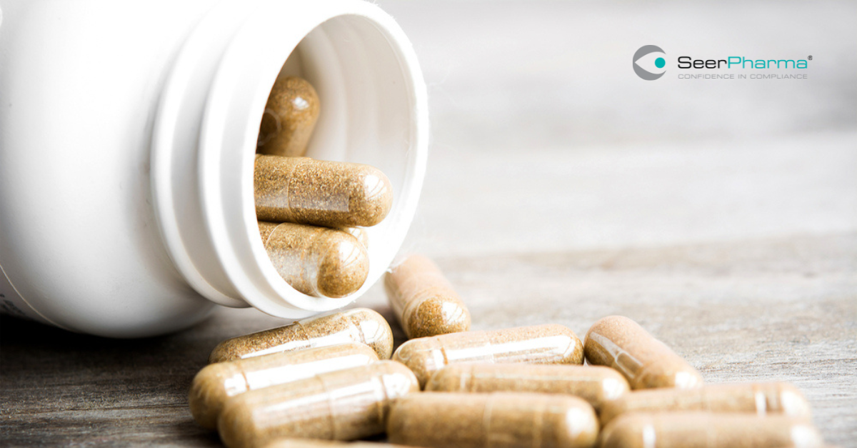 Complementary-medicine-capsules-spilling-out-of-bottle
