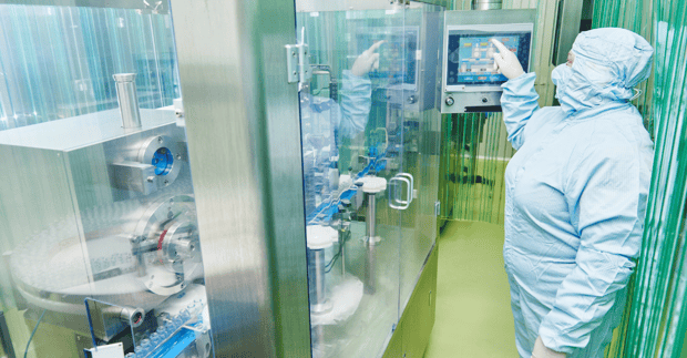 GMP operator working in grade B space of a sterile product vial filling line
