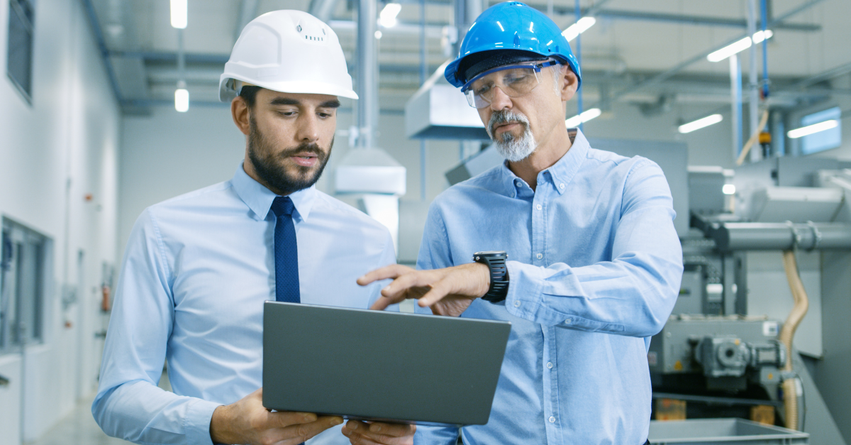 Head of the Project Holds Laptop and Discusses Product Details with Chief Engineer while They Walk Through Modern Factory