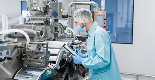 male pharmaceutical factory worker with tablet device