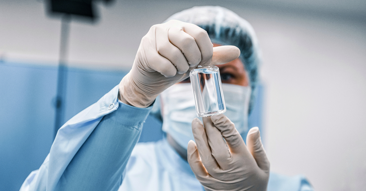 GMP Operator Holding Sterile Medicine Vial